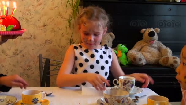 Menina sopra em uma torta com velas — Vídeo de Stock
