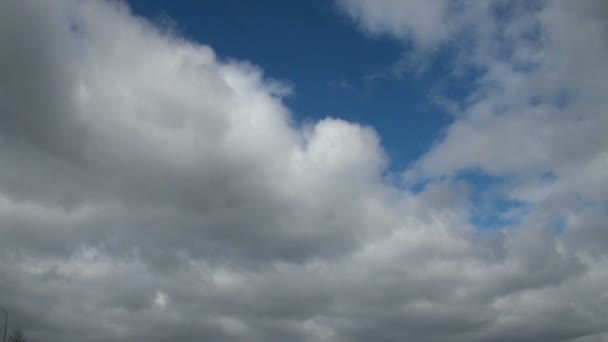 Zeitraffer-Clip von weißen, flauschigen Wolken über blauem Himmel — Stockvideo