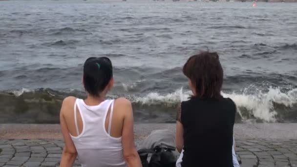 Una chica se sienta a orillas del río — Vídeo de stock