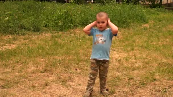 Kleiner Junge auf dem Gras — Stockvideo