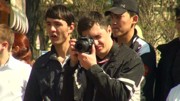 Az ember egy fényképezőgéppel a kezében, az utca — Stock videók