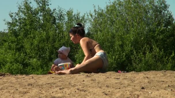 Matka se svým dítětem na pláži — Stock video