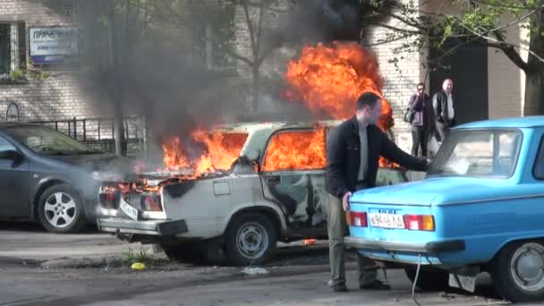 Ogień z maską silnika samochodu na ulicy miasta — Wideo stockowe