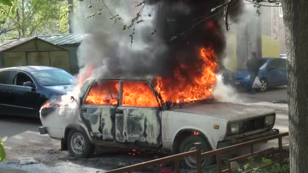 Пожар с автомобильного капота на городской улице — стоковое видео