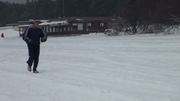 Человек, бегущий по снегу — стоковое видео