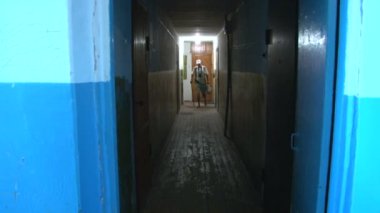bir adam koridordan yürürken