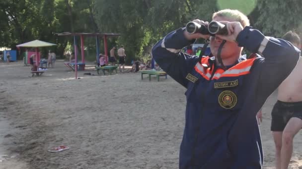 Rescatador con prismáticos en la playa — Vídeo de stock