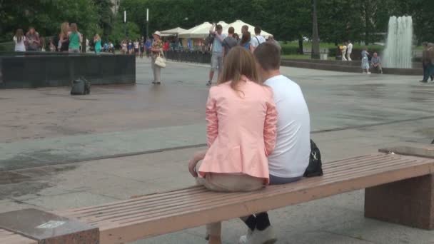 Loving couple on a bench by the fountain — Stock Video