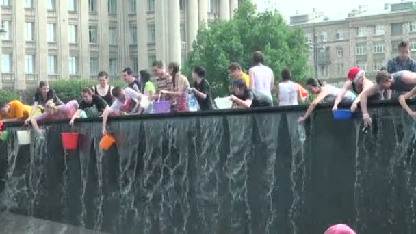 Young people trying to enter the water in a bowl and the bottle — Stock Video