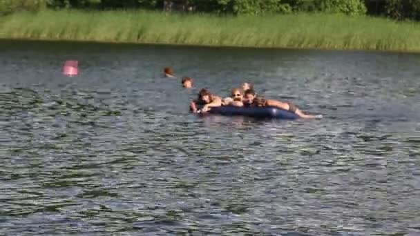 Children swim on an inflatable mattress — Stock Video