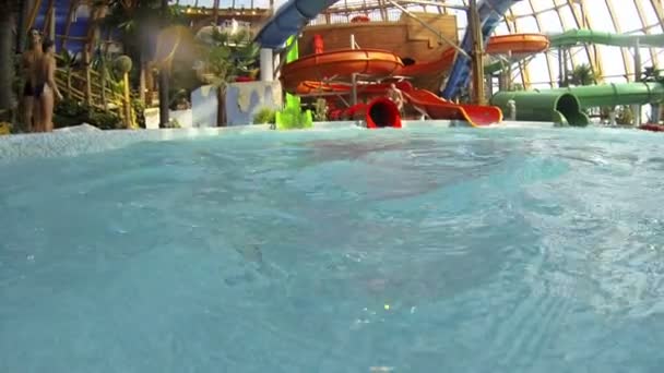 Klein meisje zwemmen in het waterpark — Stockvideo