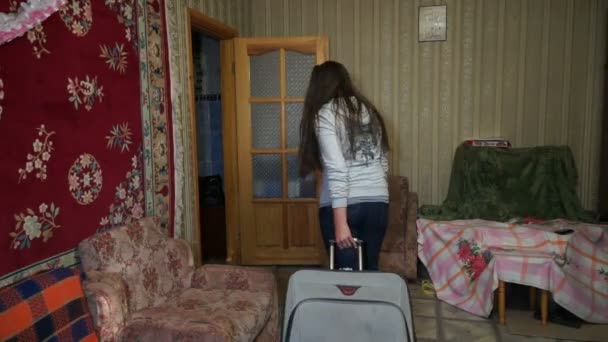 Eine Frau mit einem Koffer aus dem Haus — Stockvideo