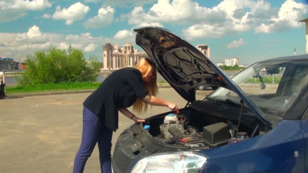 Молодая женщина ремонтирует машину — стоковое видео