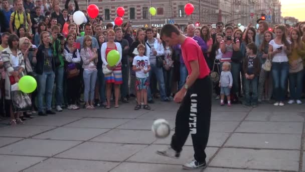 Homem malabarismo bola de futebol em uma rua na frente da multidão — Vídeo de Stock