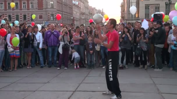 Homme jonglant avec le ballon de football dans une rue devant la foule — Video