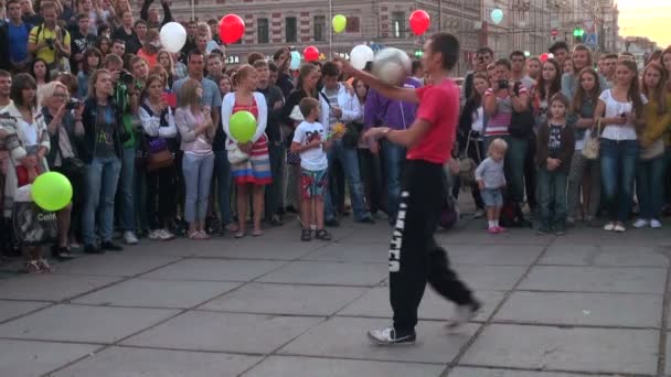 Man juggling soccer ball on a street in front of crowd — Stock Video