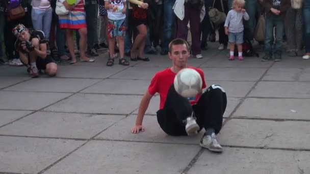 Adam futbol topu bir caddede kalabalığın önünde hokkabazlık — Stok video