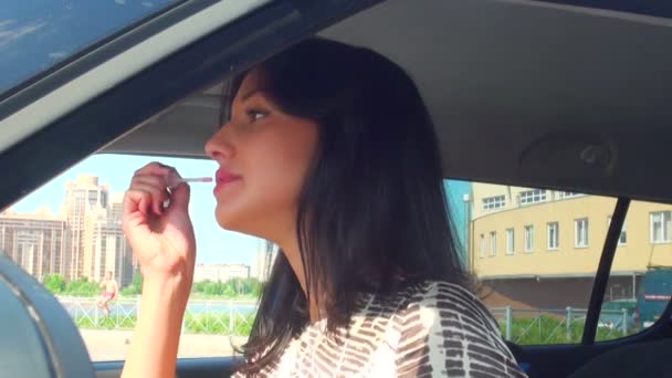 Brunette in the car doing makeup — Stock Video