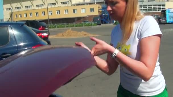 Блондинка відкриває капота автомобіля — стокове відео