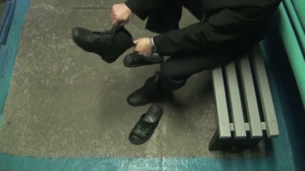 Поміщений у в'язницю людина ставить взуття. — стокове відео