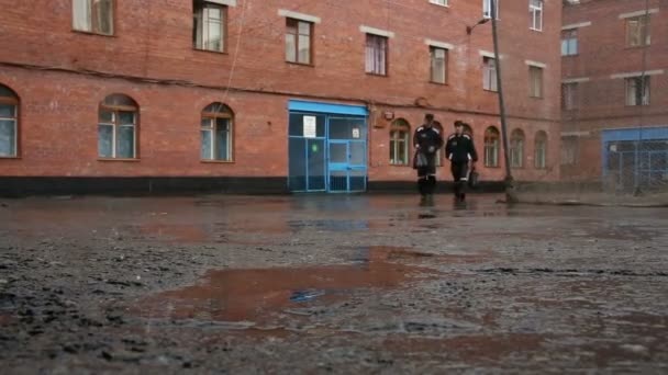 Prisoners in yard of the building under a rain — Stock Video