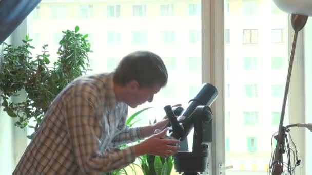 Adolescente olha através de um telescópio — Vídeo de Stock