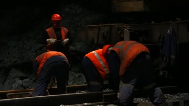 Железнодорожники прикручивают рельсы к балласту — стоковое видео