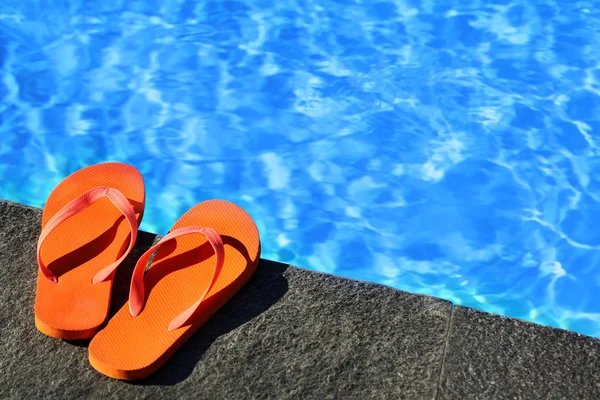 Sandaalit uima-altaan luona — kuvapankkivalokuva