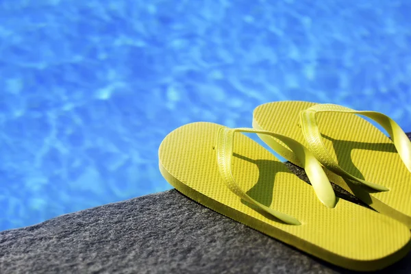 Sandálias por uma piscina — Fotografia de Stock