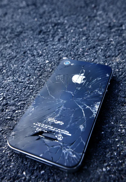 IPhone preto com exibição quebrada que coloca no asfalto — Fotografia de Stock