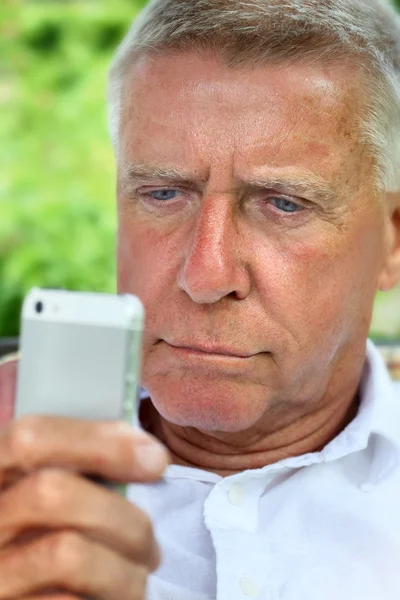 Senior browsing on a smart phone — Stock Photo, Image
