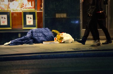 Homeless man sleeping on the street clipart