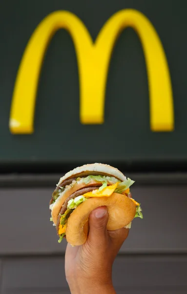 Man's handen, vasthouden aan een hamburger — Stockfoto