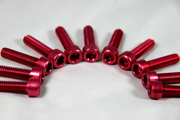 Red anodized hexagon socket / screw — Stock Photo, Image