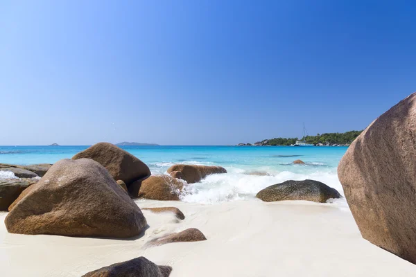 White coral beach sand and azure indian ocean. Sailing yacht on — Stock Photo, Image