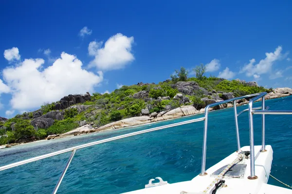 Witte jacht in de buurt van rotsachtige kust van de Seychellen. — Stockfoto