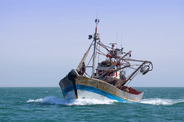 Un barco pesquero está pescando en el mar . — Foto de Stock