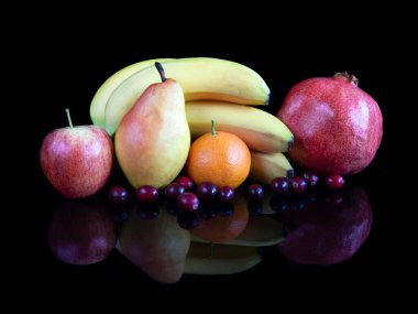 Fruits on reflective black studio background