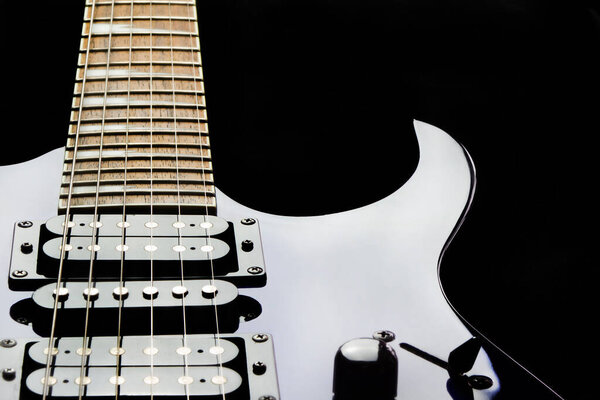 Close up of an electric guitar on black background