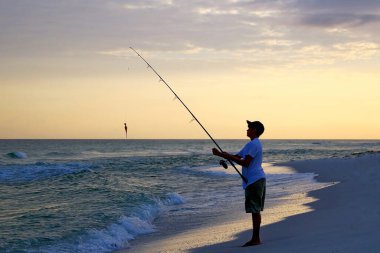Pensacola Sahili 'nde balık tutan genç bir çocuk.