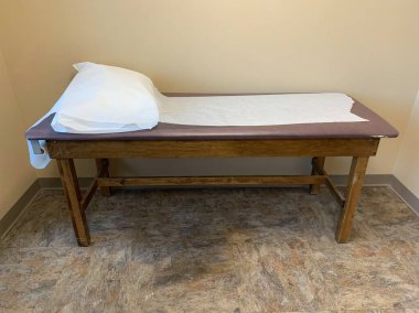 Doktorun muayenehanesinde muayene masası.