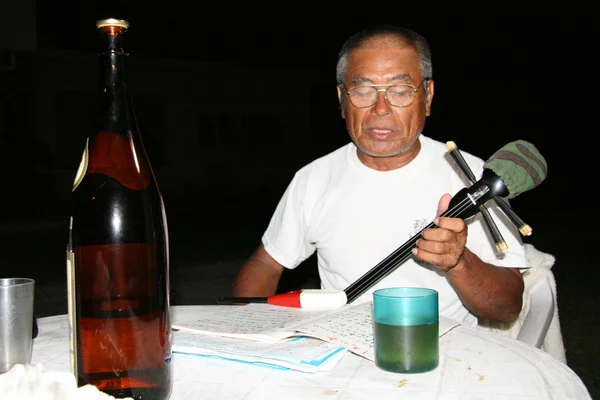 Gammal man spelar sanshin gitarr, okinawa, japan — Stockfoto