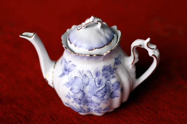 Pot à thé en porcelaine florale antique sur fond rouge — Photo