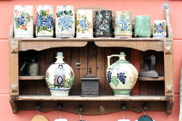 Ceramic mugs and old objects on a rack — Stock Photo, Image