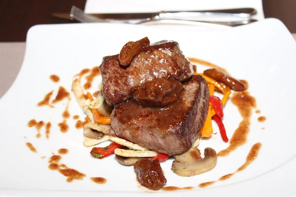 Close up scene with grilled beef with vegetables on white plate — Stock Photo, Image