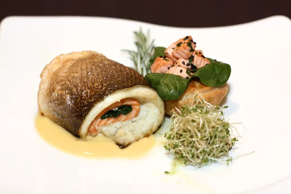 Pescado en plato blanco sobre fondo oscuro — Foto de Stock