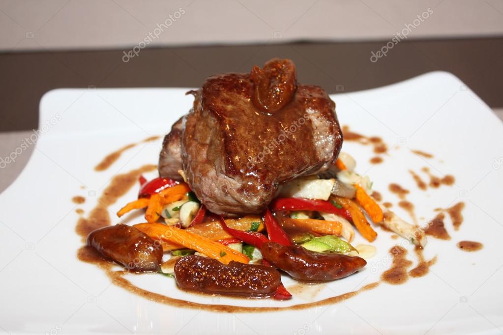 Grilled beef with vegetables on white plate