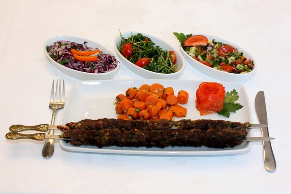 Carne a la parrilla con salteada de zanahorias y ensalada en plato blanco —  Fotos de Stock