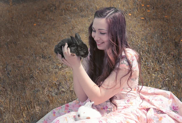 Girl holding a black rabbit — Stock Photo, Image