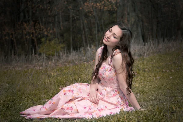 Fille rêveuse qui est assis sur l'herbe — Photo